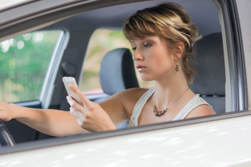 Woman texting and driving at the same time.